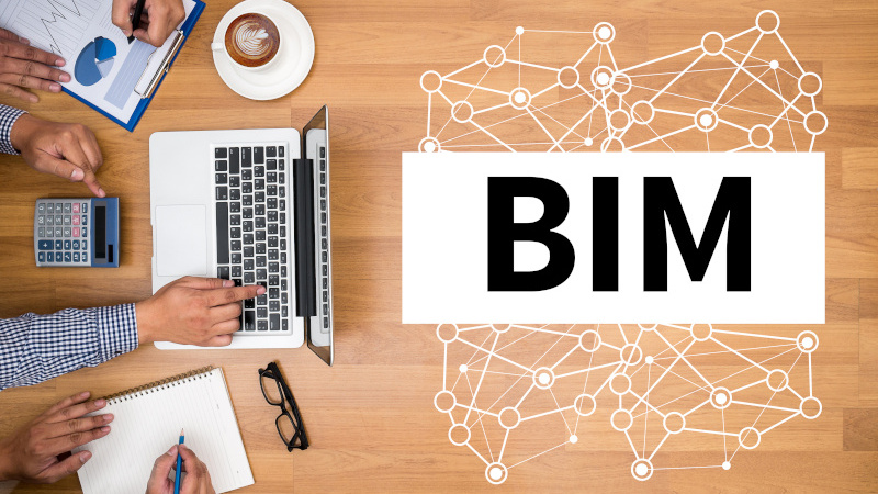 BIM Business team hands at work with financial reports and a laptop